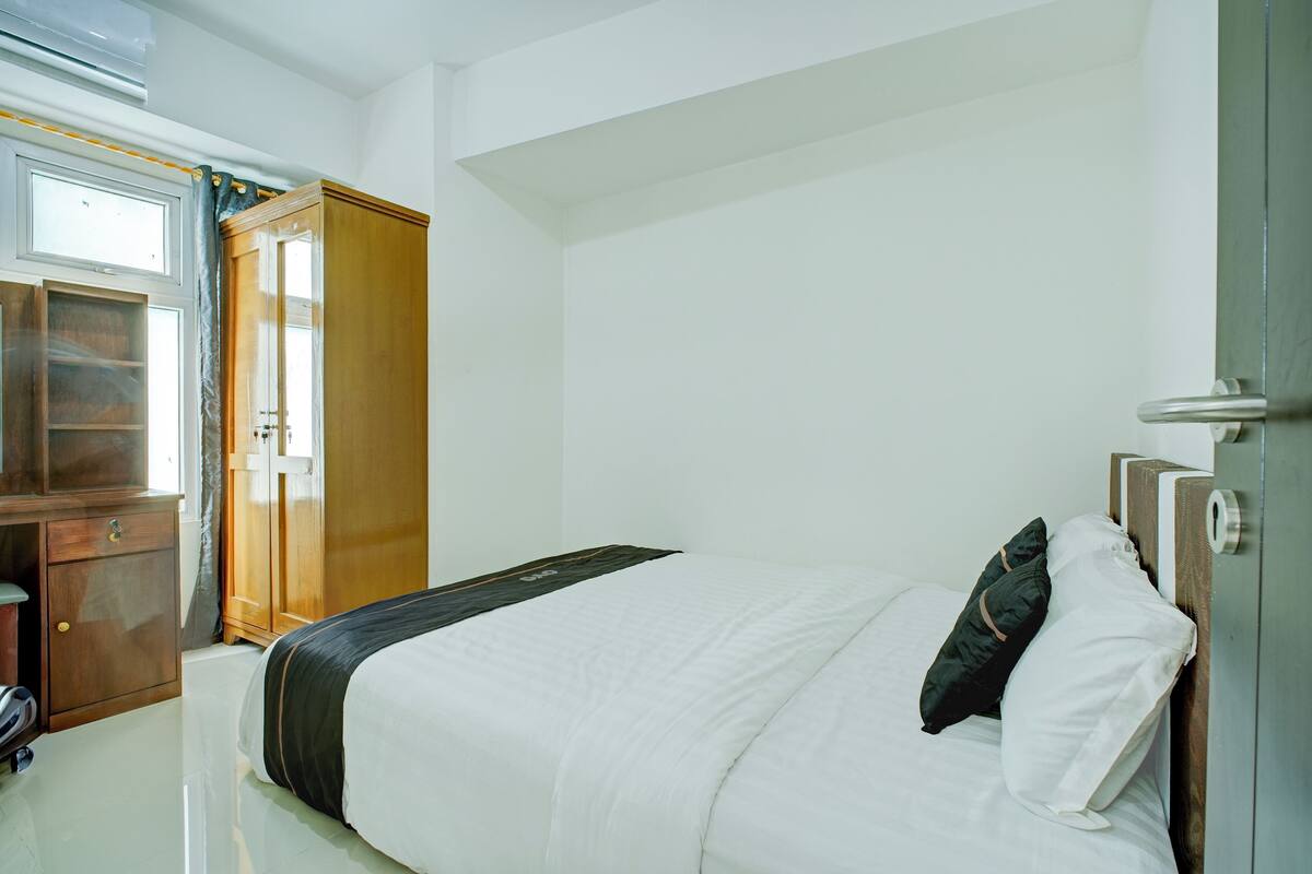 Habitació d'hotel amb llit, armari i escriptori.