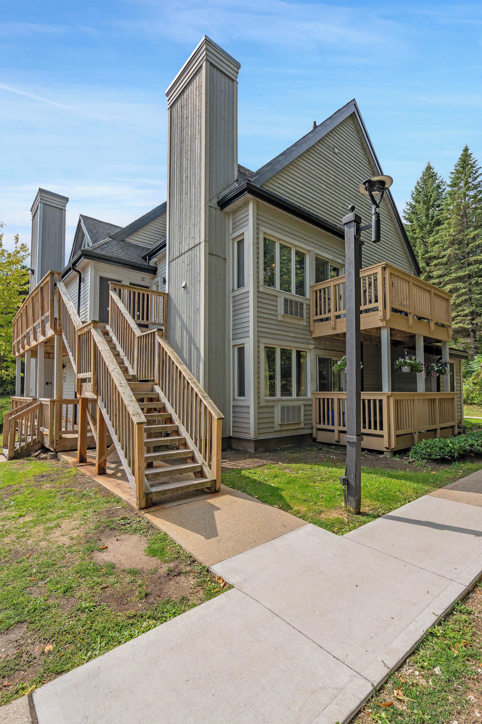 A two-story house with a wooden staircase, a balcony, and a chimney.