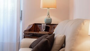 A cozy living room with a beige sofa, a lamp, and a small wooden side table. - Ca' Orso Marino (Venice)