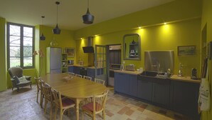 A kitchen with a dining table and chairs, a refrigerator, and a sink. - Country house in town. (Angoulême)