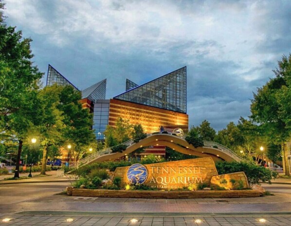The Tennessee Aquarium entrance with a large sign, a bridge, and surrounding trees. - French Country Charm in Chatt Town - large space for entertaining and parking! (Ringgold)