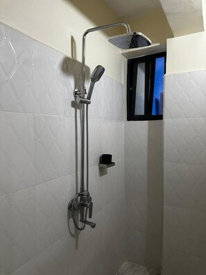 Ducha con cabezal de ducha de mano y grifo empotrado.