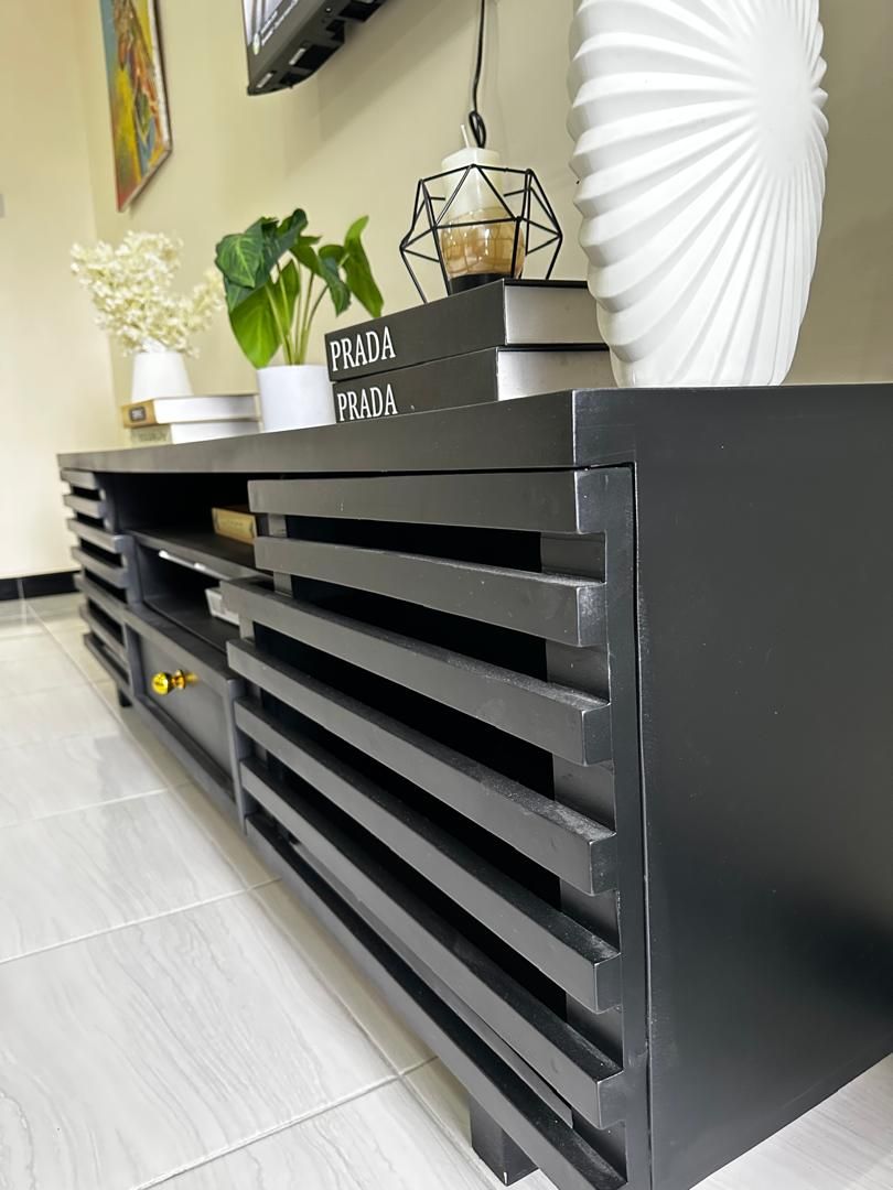 A reception desk with a black surface and a sign that reads "PRADA PRADA".