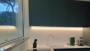 Una cocina moderna con un lavamanos, encimera y ventana.