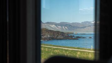 A coastal landscape with rocky outcrops and a clear blue sea.