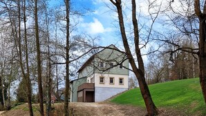 Ein Haus mit geneigtem Dach, einer Haustür und einer sichtbaren Treppe, die zum Eingang führt.