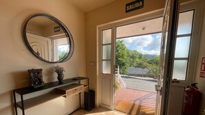 A hotel entrance with a reception desk, a mirror, a 'SALIDA' sign, and a view of the outside. - Trasgu House for 6 people in Infiesto (infiesto, piloña)