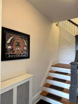 A staircase with a framed picture of a stadium on the wall.