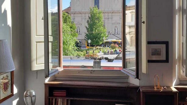 Una habitación con un amplio ventanal que ofrece vistas a un edificio clásico.