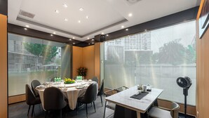 A modern dining area with a round table set for six, surrounded by chairs.