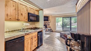 A modern kitchen with wooden cabinets, a built-in microwave, and a dishwasher. - Ski-In, Ski-Out From Studio, Ground Floor, Dog Friendly (Breckenridge)