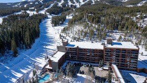 A hotel with a ski slope in the background, surrounded by snow-covered mountains. - Ski-In, Ski-Out From Studio, Ground Floor, Dog Friendly (Breckenridge)