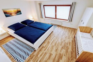 Ein Schlafzimmer mit einem Bett, einem Heizkörper, einem Fenster und einem Gemälde an der Wand.