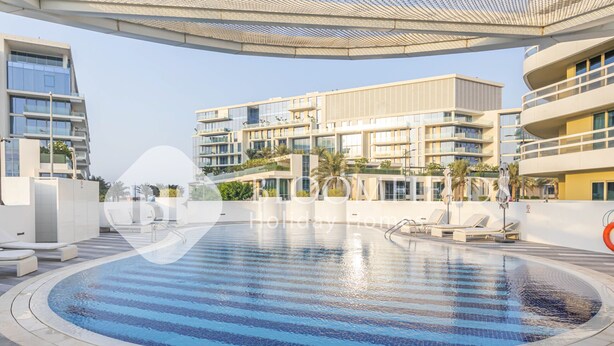 Um hotel moderno com uma grande piscina ao ar livre, várias varandas e um design arquitetônico contemporâneo.
