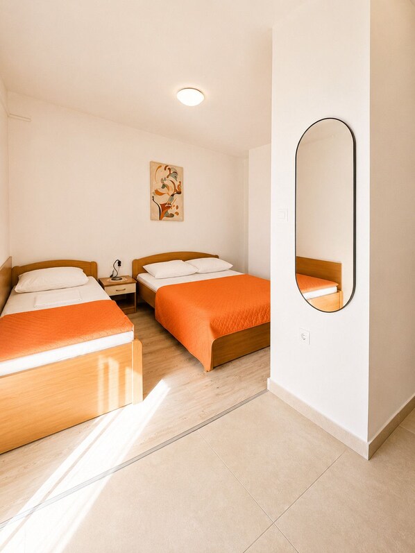 A hotel room with two beds, a nightstand, a wall-mounted mirror, and a ceiling light. - Studio apartment Lea (Zaton)