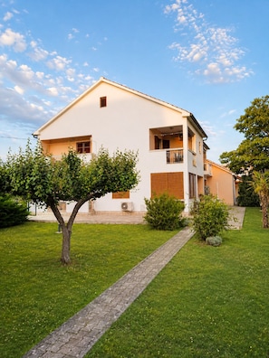 A two-story building with a paved pathway leading to the entrance. - Apartment Olinda (Zaton)