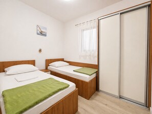 A hotel room with two beds, a sliding door, a window with sheer curtains, and a small wall-mounted artwork. - Apartment Olinda (Zaton)