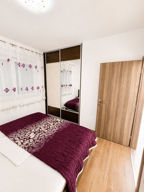 Ein Schlafzimmer mit einem Bett, einem Kleiderschrank und einem Spiegel.