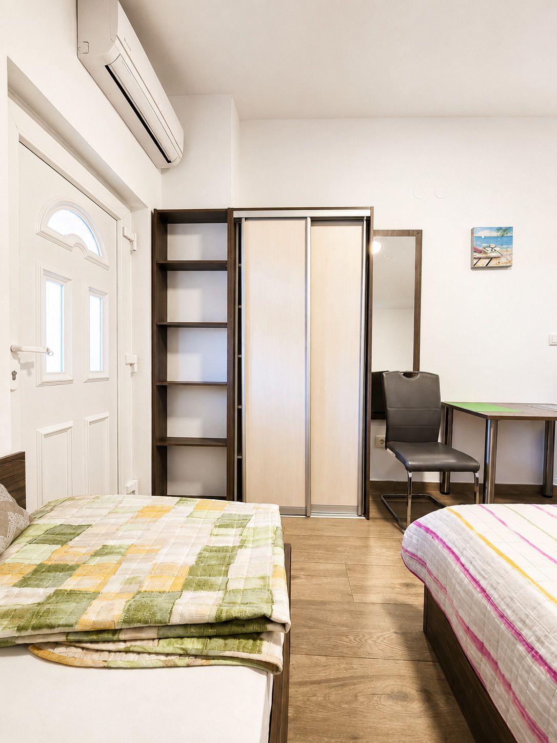Un dormitorio con cama, escritorio, silla y armario.