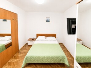 A hotel room with a bed, a nightstand, a mirror, and a small picture on the wall. - Studio apartment Vita (Zaton)