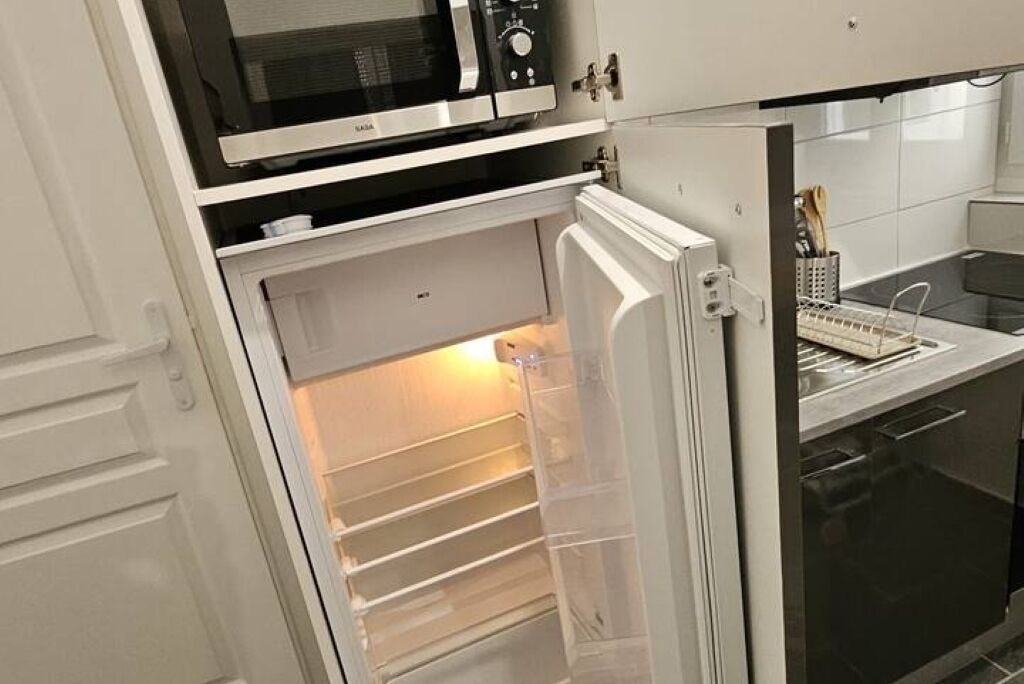 Une cuisine équipée d’un four à micro-ondes, d’un réfrigérateur et d’un lave-vaisselle.