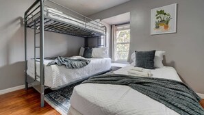 A bunk bed room with a window, a small plant, and a patterned rug. - Relaxing 3BR townhome w/ resort access (Kissimmee)
