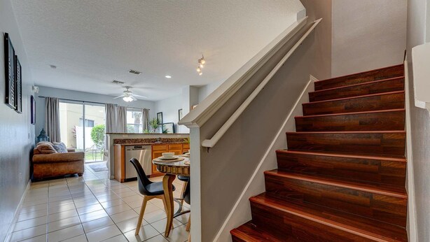 A spacious living area with a kitchen, a dining table, and a staircase. - Relaxing 3BR townhome w/ resort access (Kissimmee)