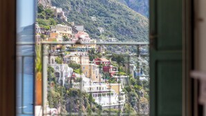 A coastal town with buildings on a hillside, a clear view of the sea, and a prominent church spire. - Sea Soul Positano (Positano)
