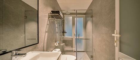 A modern bathroom with a large bathtub, toilet, and shower area.