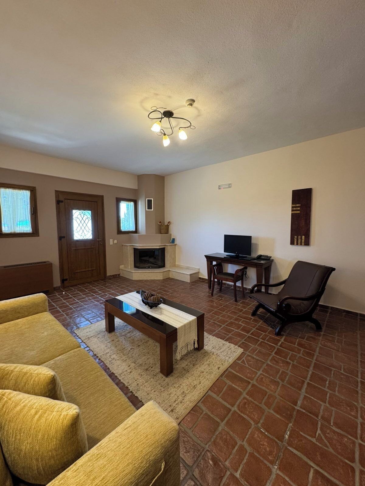 A living room with a fireplace, a television, a sofa, and a coffee table.