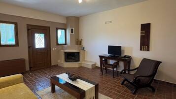 A living room with a fireplace, a television, a sofa, and a coffee table.