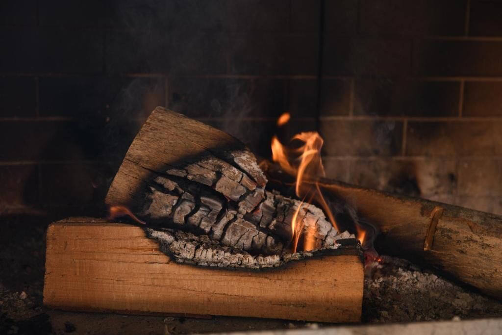 A fireplace with burning logs and visible flames.