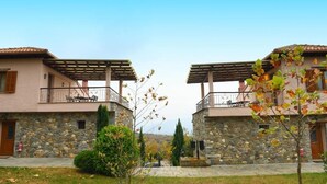 Un immeuble de deux étages, avec des murs en pierre et un balcon à chaque étage.
