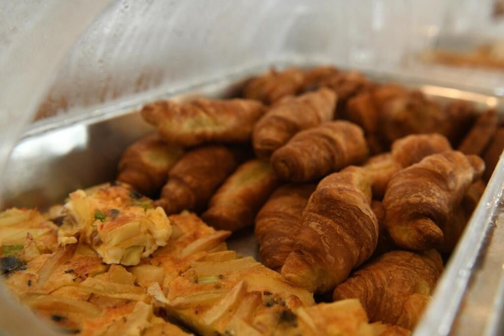 Un buffet proposant des croissants et un plat qui ressemble à une sorte de gratin.