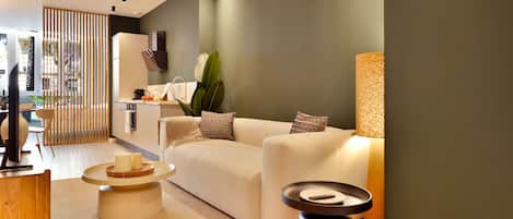 A modern living room with a beige sofa, a round coffee table, and a side table.