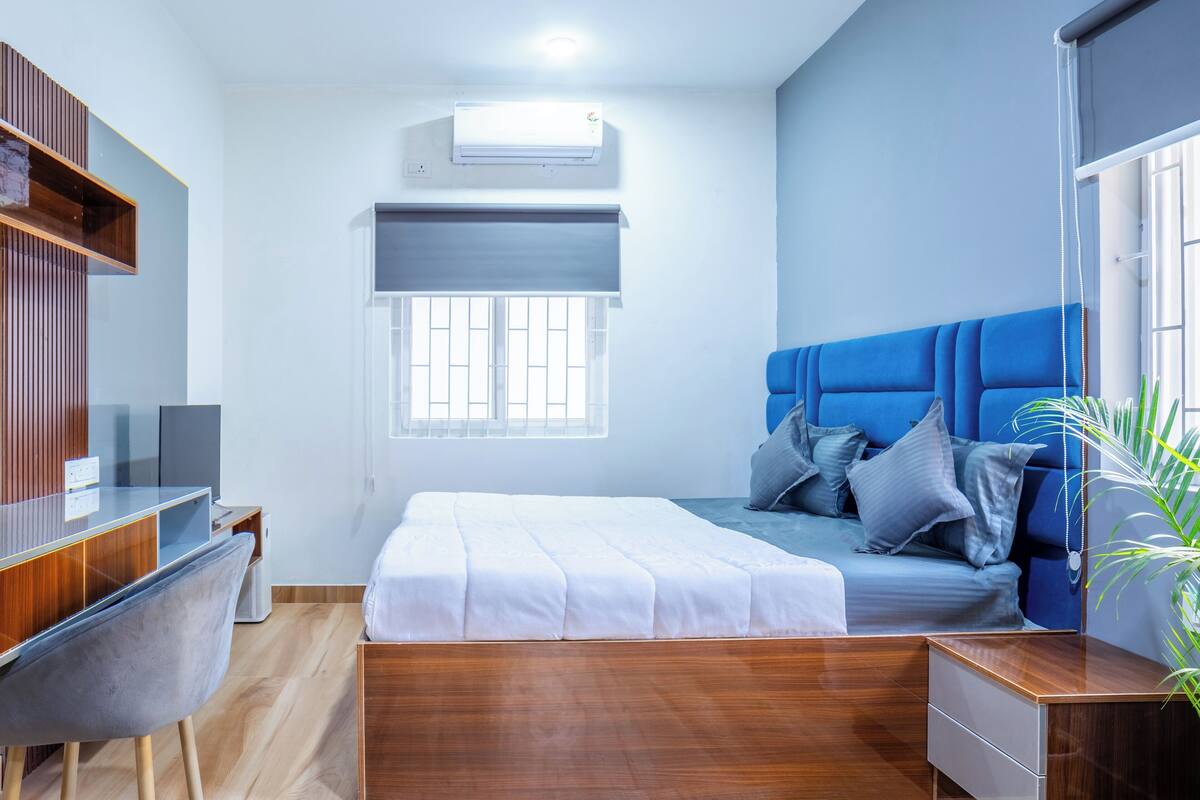 Un dormitorio moderno con una cama de madera, un escritorio y una silla.
