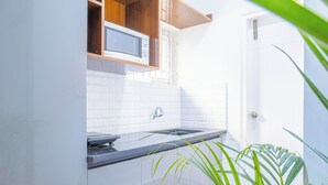 Una cucina moderna con forno a microonde, lavello e pensili in legno.