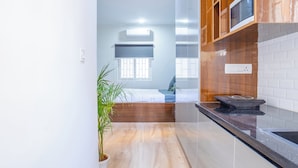 Una cucina moderna con un piano di lavoro in legno, un forno a microonde integrato e una pianta in vaso.