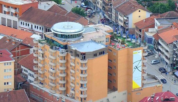 Standing atop this vibrant cityscape, the building's circular rooftop offers panoramic views.