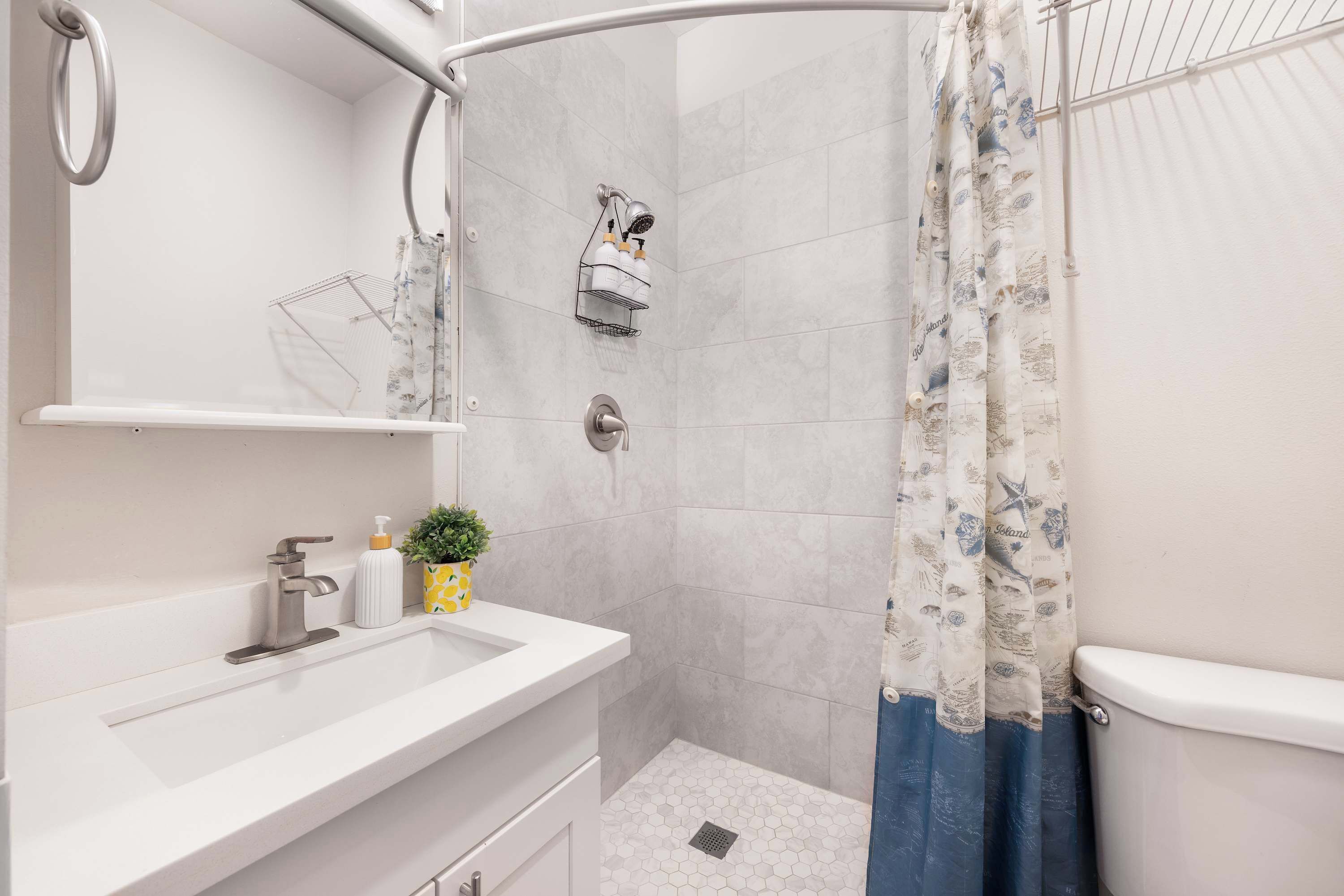 A modern bathroom with a shower, a sink, and a toilet.