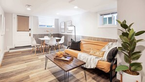 Ein modernes Wohnzimmer mit Sofa, Couchtisch und Essbereich.