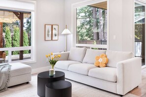 A modern living room with a sofa, a round black side table, and a lamp.