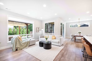 A modern living room with a sofa, coffee table, and dining area.