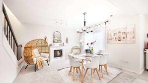 Una sala moderna con comedor, chimenea y escalera.