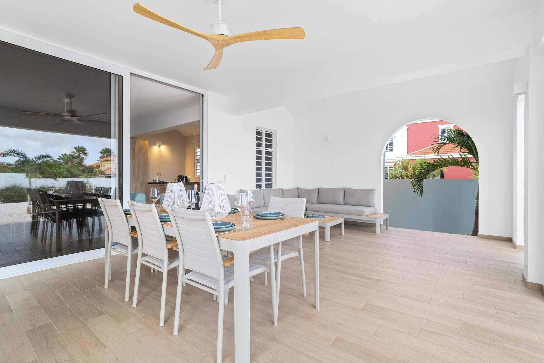Ein modernes Wohnzimmer mit Essbereich, großen Fenstern und Blick ins Freie.