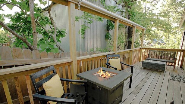 Una terrazza esterna con un braciere, sedie in legno e una panca.