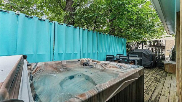 A hot tub with a wooden deck, a covered grill, and a fence. - Traveling together but want space and privacy? (Eureka Springs)