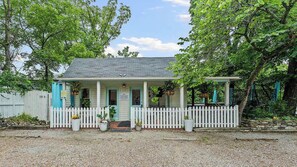 A single-story building with a porch, white picket fence, and potted plants. - Traveling together but want space and privacy? (Eureka Springs)