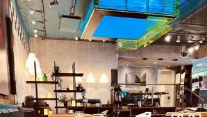 Un interior moderno con una mesa de comedor de madera, sillas blancas y una zona de cocina al fondo.