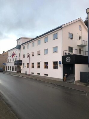 A multi-story building with a flat facade, several windows, and a small balcony on the upper floor. - Arctic Boutique Hotel by STAY 9750 (Honningsvåg)